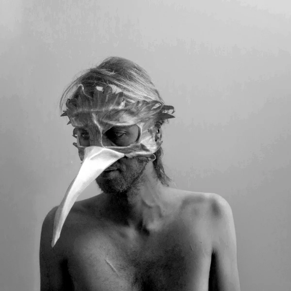 Spooky black and white photo of Ivy wearing a bird mask